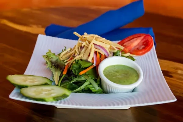 Close-up of a fresh salad with vegetables, dressing, and crispy topping.