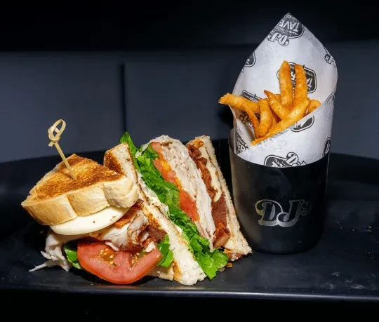 Club sandwich with turkey, bacon, and crinkle-cut fries.