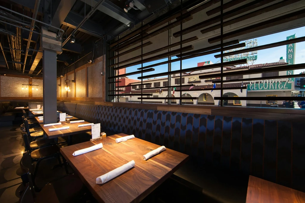 Industrial restaurant interior, tables, booths, and 'EL CORTEZ' street view.