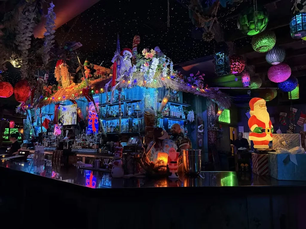 Low-lit bar decorated elaborately with Tiki and Christmas themes.