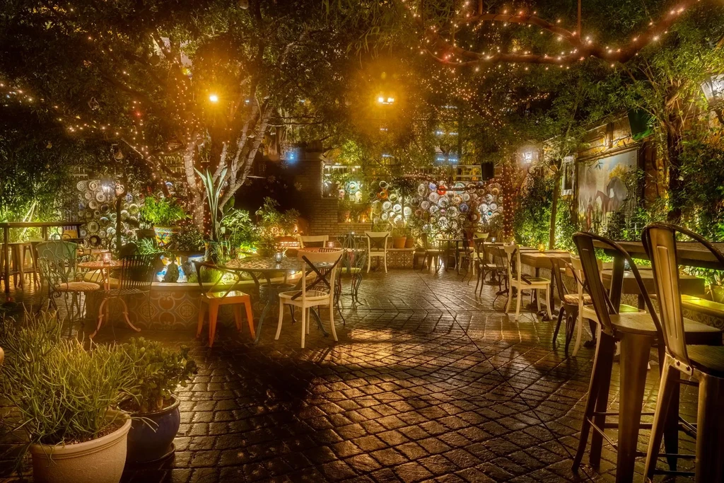 Empty outdoor restaurant patio at night, lit by string lights.