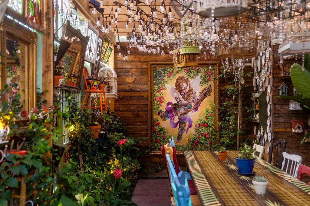 Vibrant restaurant interior with lush plants, eclectic decor, and unique art.