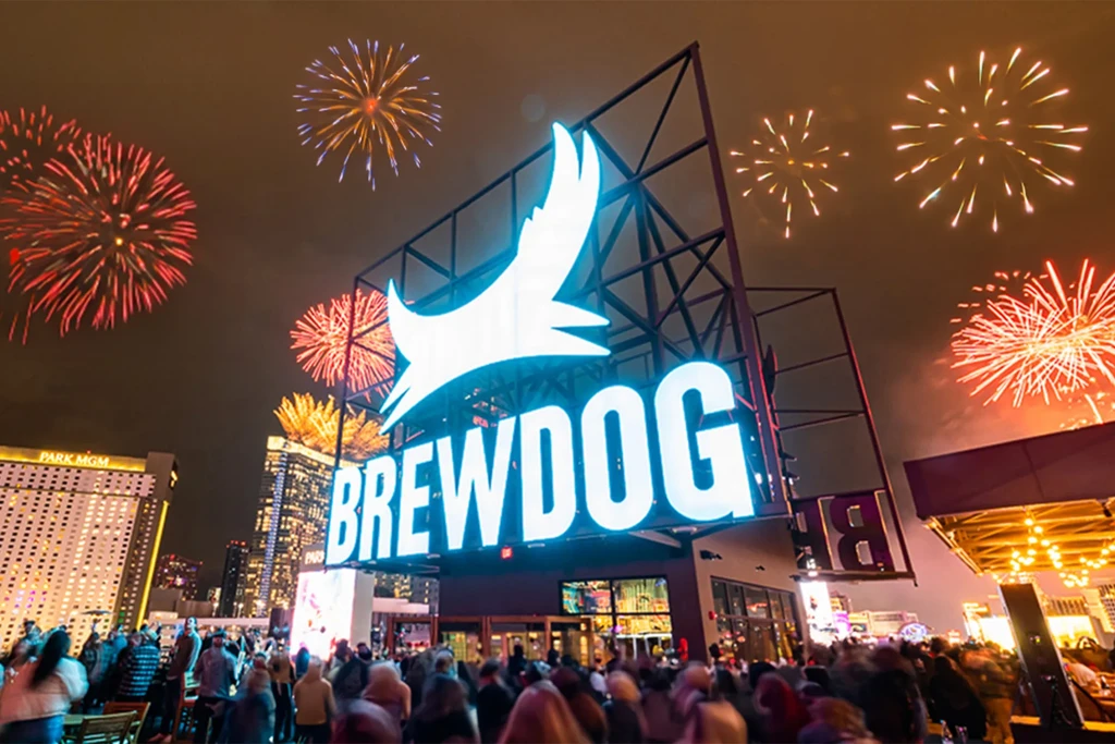 Brewdog exterior at night, colorful fireworks above a large crowd.