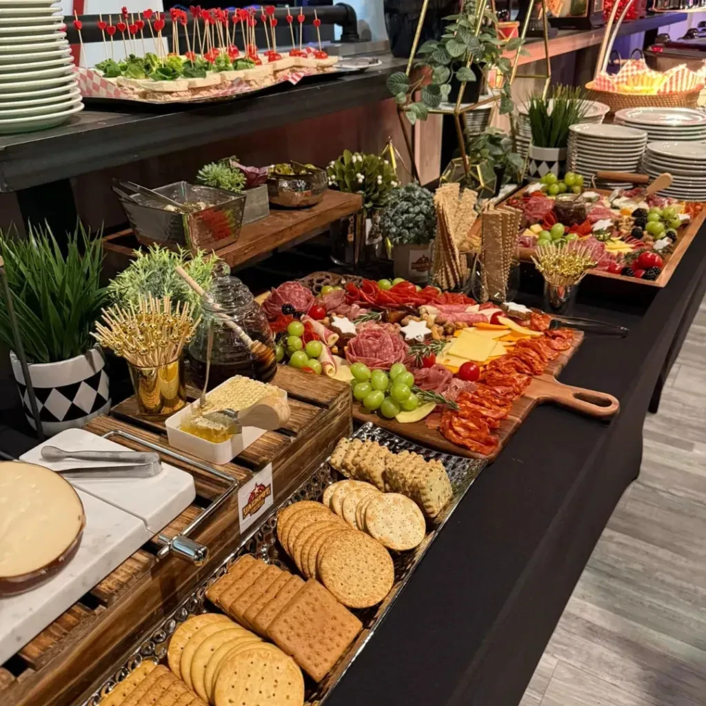 Lavish buffet table with charcuterie, cheeses, fruit, crackers, and appetizers.