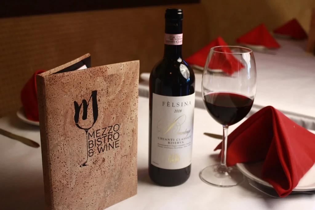Set restaurant table with Chianti wine, glass, and bistro menu.