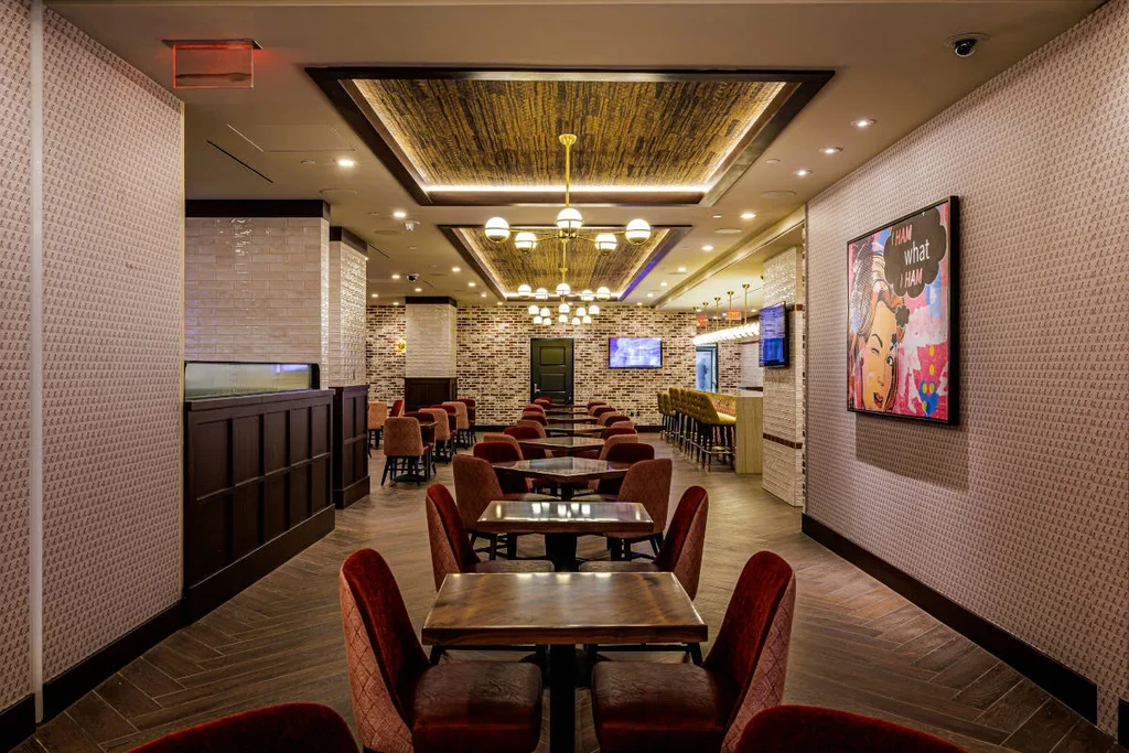 Empty modern restaurant interior, long dining area leading to a bar.