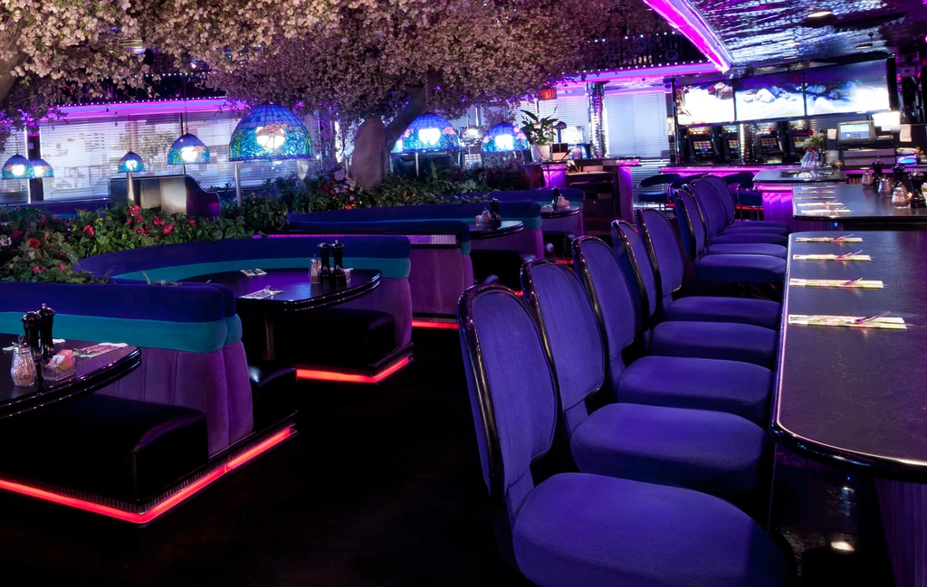Restaurant interior: purple stools, blue booths, red neon, cherry blossoms, stained glass lamps.