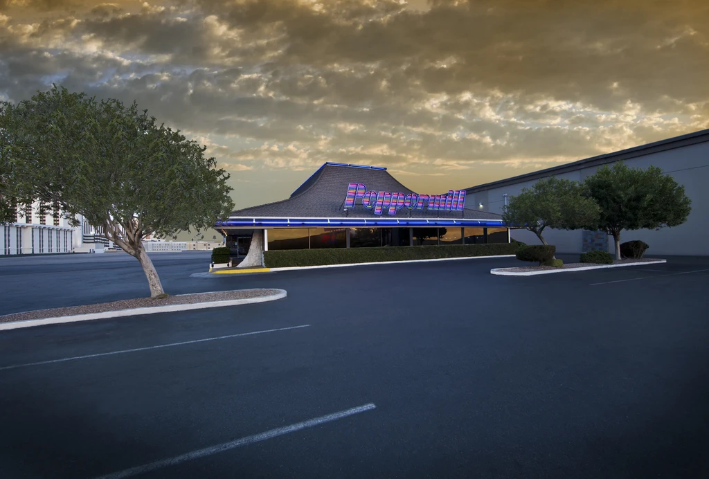 Peppermill restaurant at dusk with colorful neon sign and dramatic sky.
