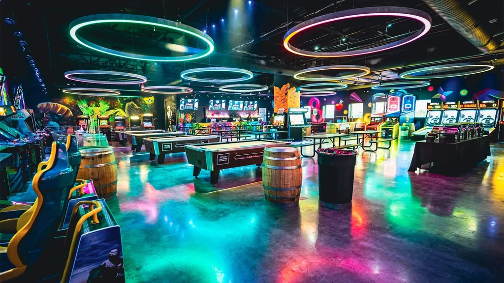 Neon-lit futuristic arcade, pool hall, and bar area.