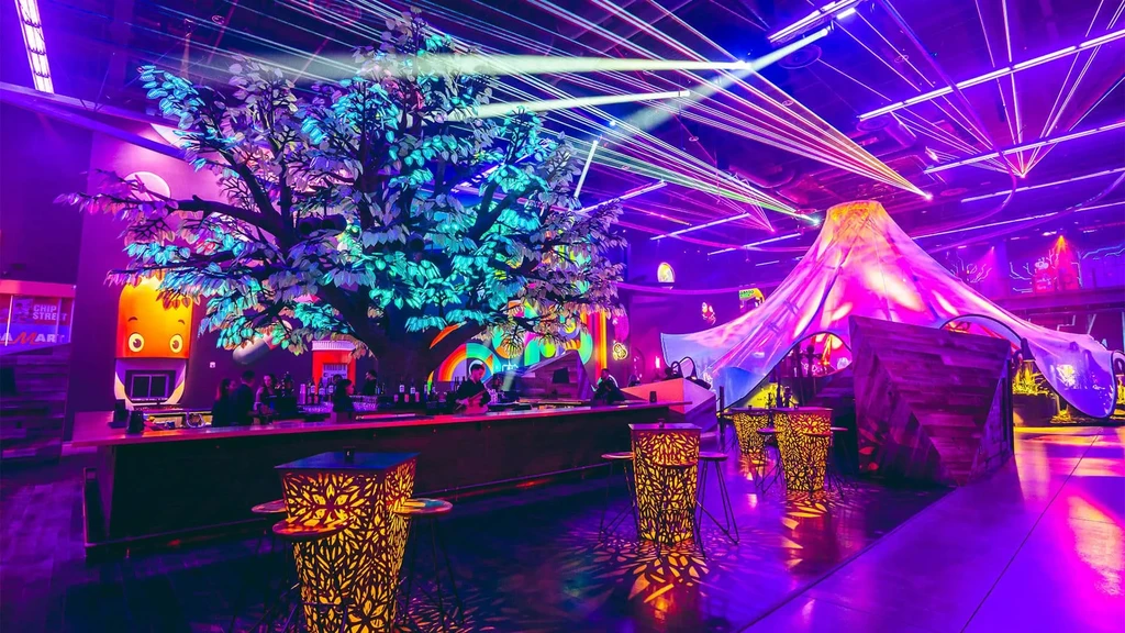 Futuristic bar with purple neon, glowing tree, and laser lights.