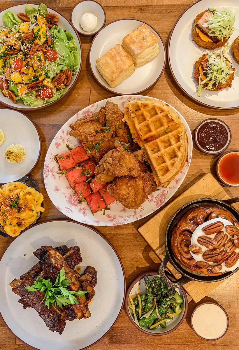 Overhead spread of salad, biscuits, ribs, mac and cheese