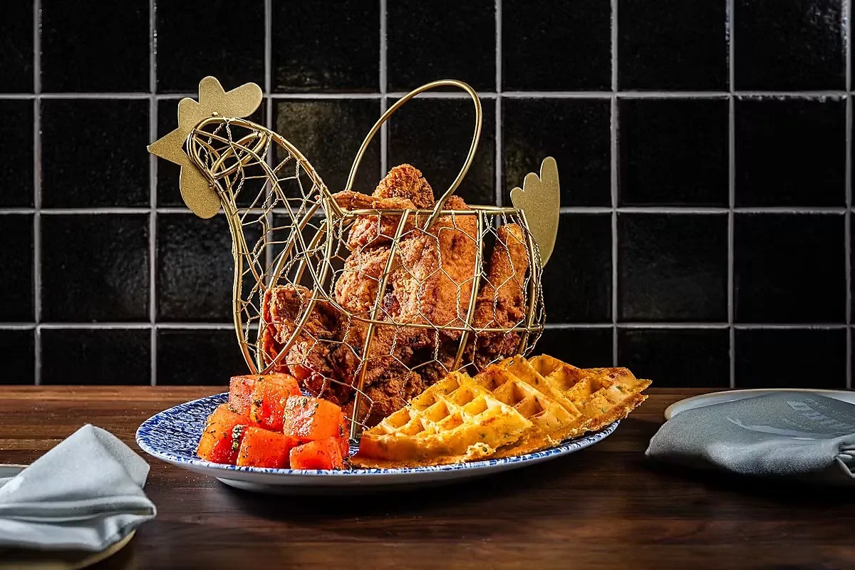 Fried chicken in wire hen basket with waffles and watermelon