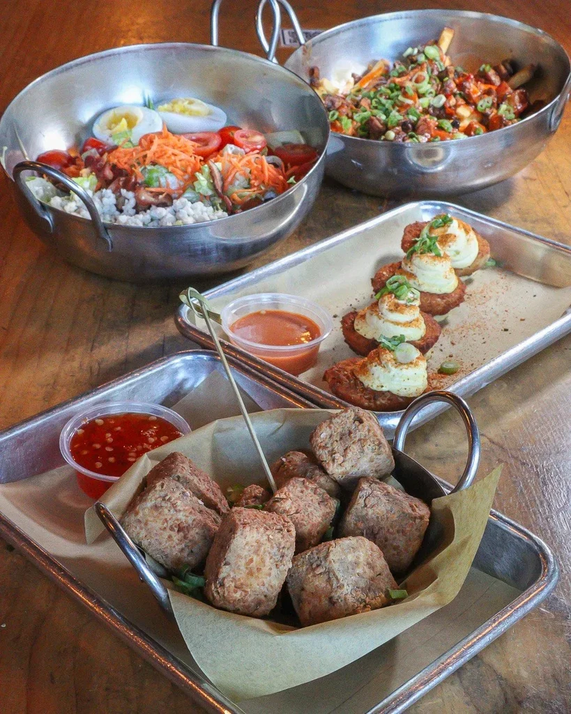 Fried appetizers, salad, and loaded fries served on a rustic table.