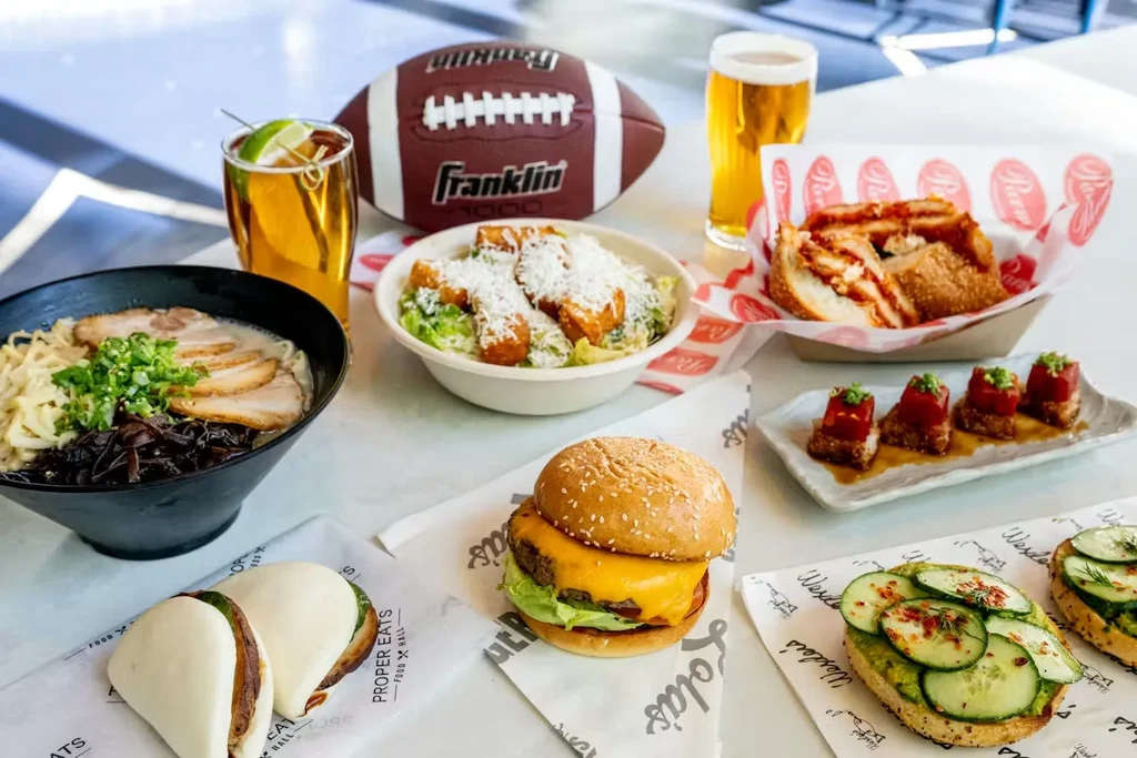 Overhead view of diverse restaurant dishes, drinks, and a football.