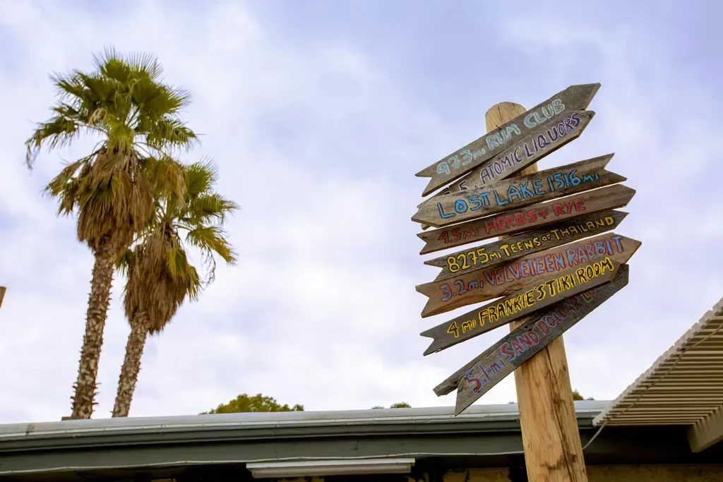 Colorful rustic signpost with arrows for bars and restaurants.