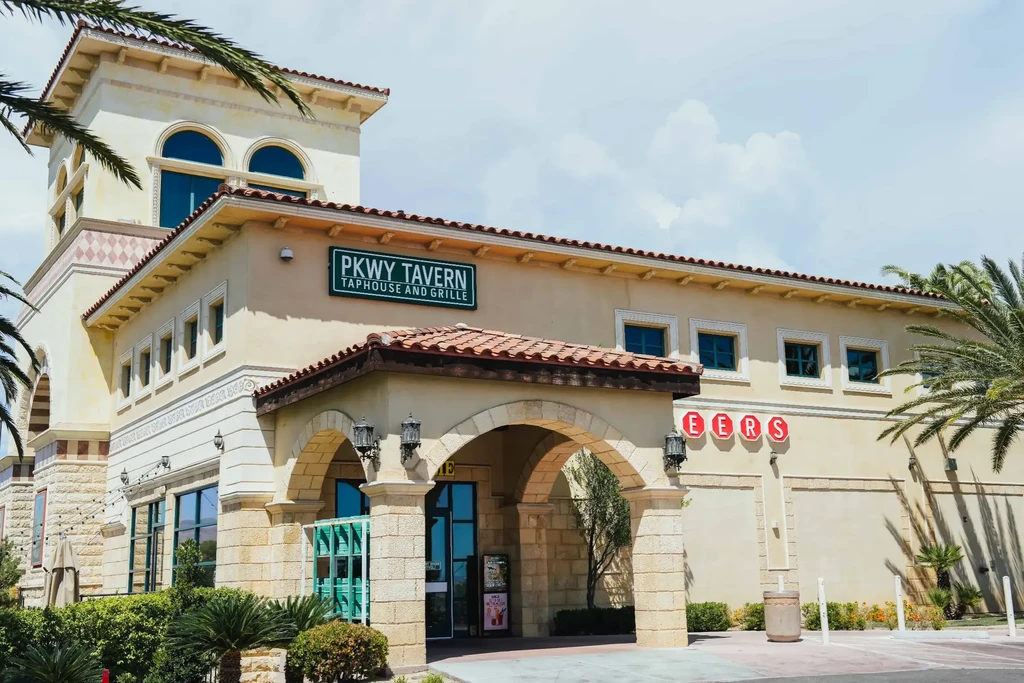 PKWY TAVERN TAPHOUSE AND GRILLE: Mediterranean stucco building, tiled roof, palm trees.