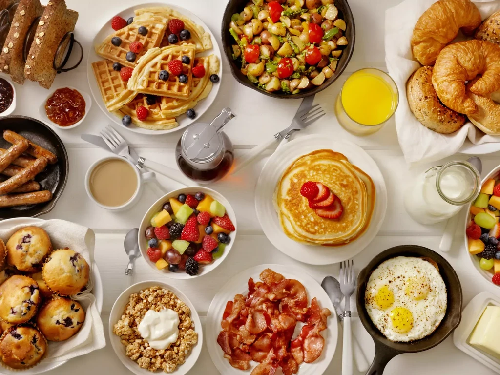 Overhead flat lay of a large, diverse breakfast and brunch spread.