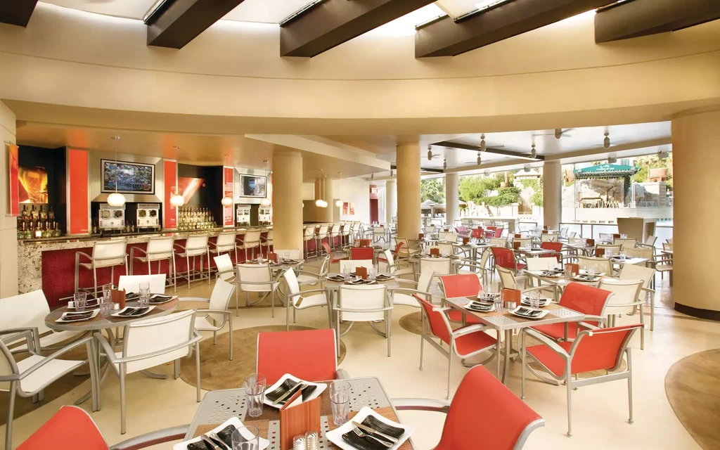 Modern restaurant with warm beige, red accents, and an outdoor patio.