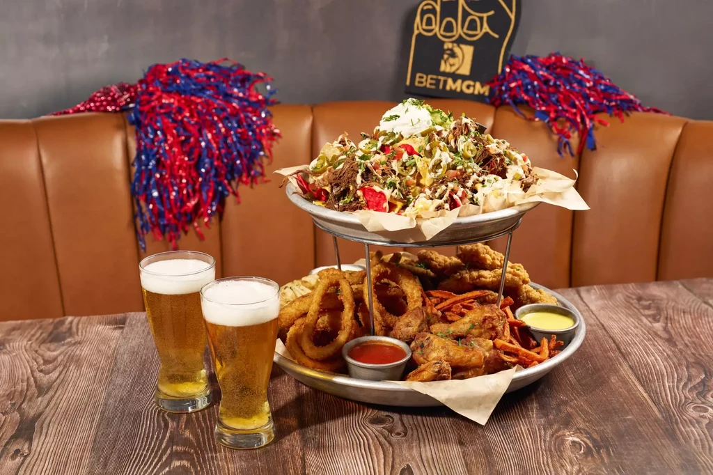 Stacked bar food: nachos, fried apps, and two beers, sports theme.