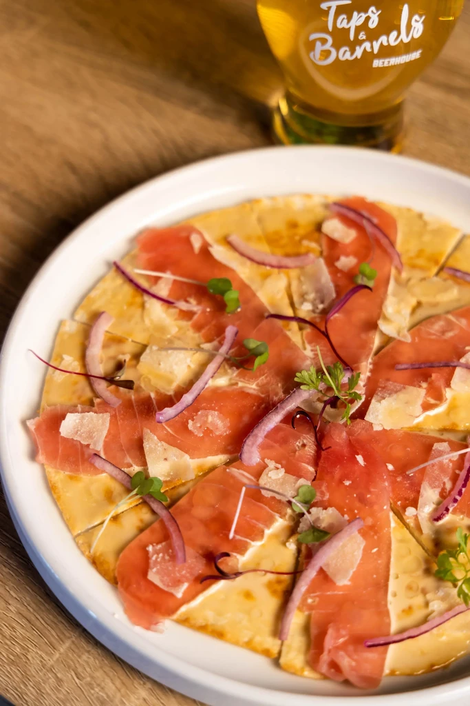 Flatbread with cured meat, red onion, parmesan, herbs, and beer.