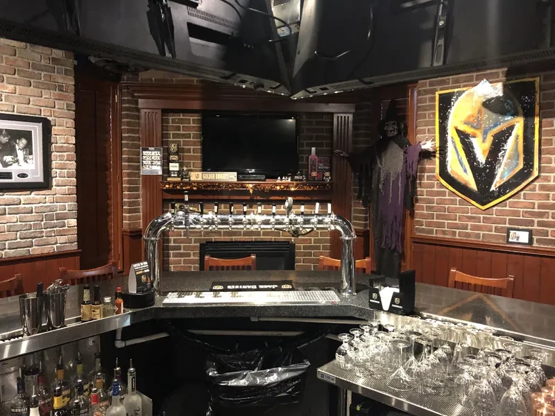 Bar corner with beer taps, liquor, Golden Knights logo, and grim reaper.