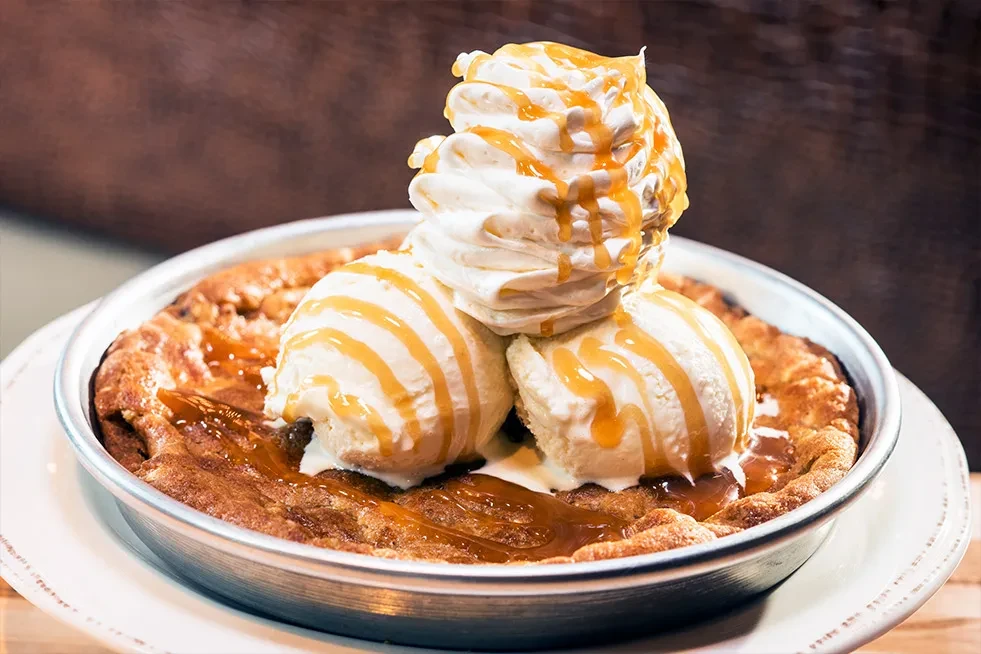Warm skillet cookie with vanilla ice cream, whipped cream, and caramel sauce.