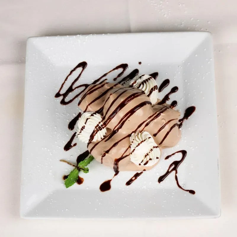 Chocolate mousse with whipped cream, mint, dark drizzle, powdered sugar.