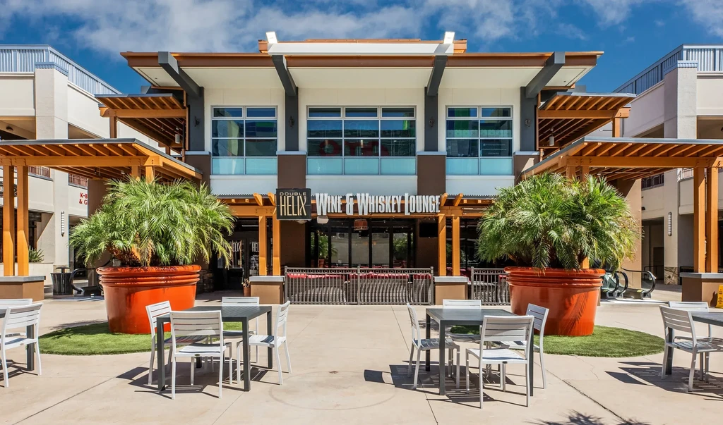 Modern "Double Helix Wine & Whiskey Lounge" exterior with outdoor plaza seating.