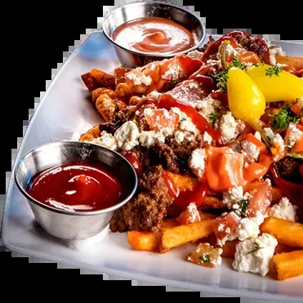 Loaded french fries topped with meat, cheese, sauces, and a yellow pepper.