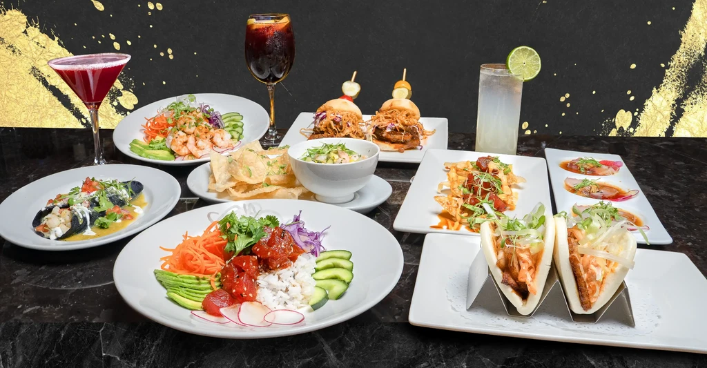 Tabletop displays diverse dishes, including poke bowls, and alcoholic drinks.