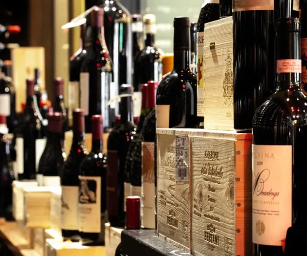 Display of numerous red wine bottles and wooden crates, some labeled Amarone.