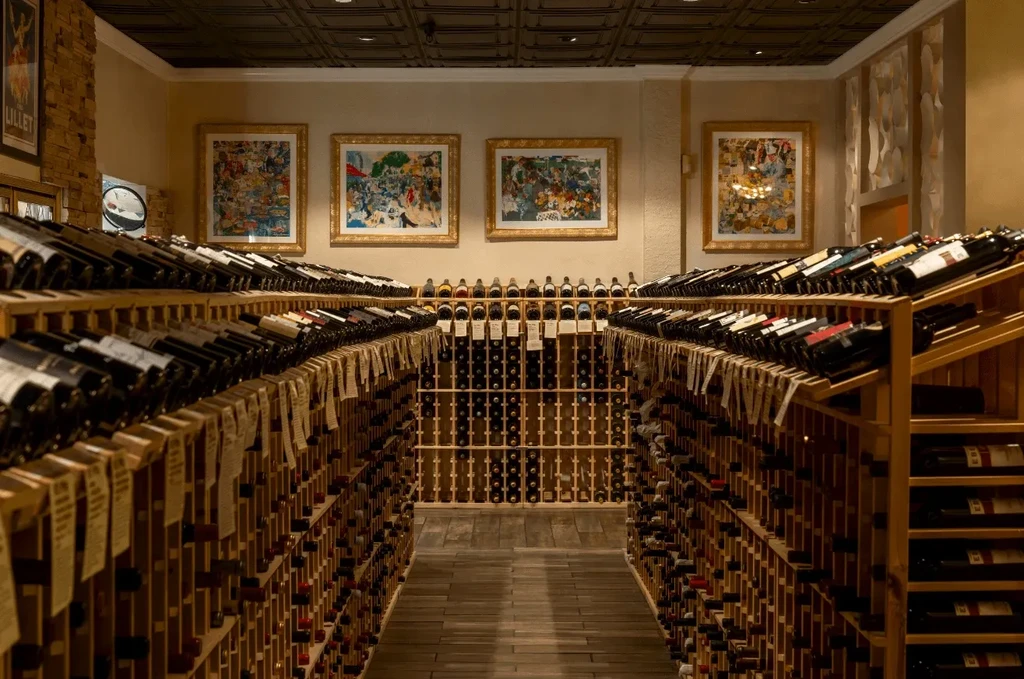 Extensive wine cellar aisle with tall wooden racks filled with bottles.