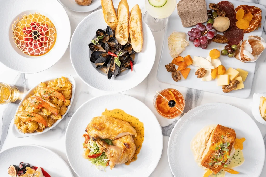 Overhead: elegant flat-lay of diverse gourmet food and drinks.