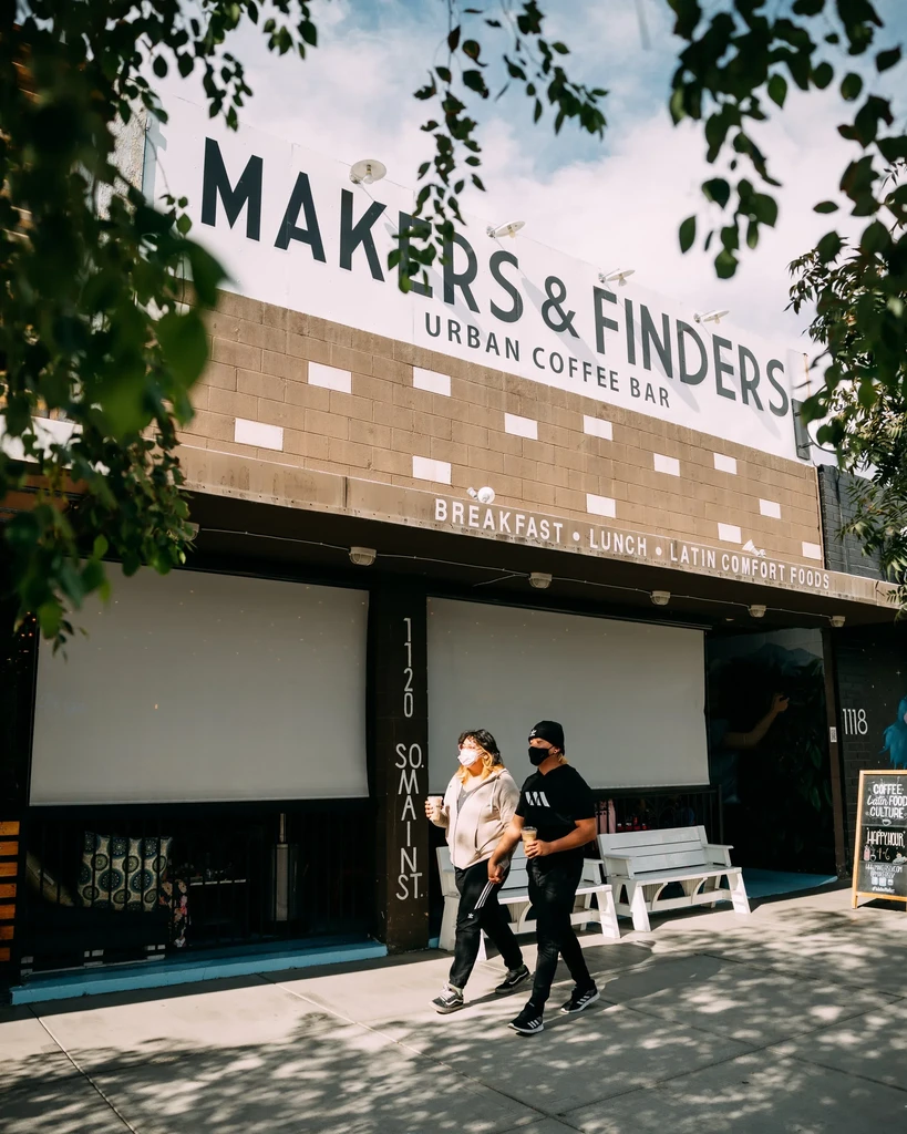 MAKERS & FINDERS urban coffee bar, two masked people on sidewalk.