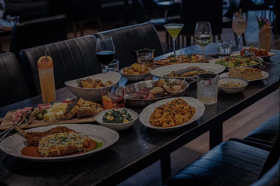 A long dark table heavily laden with a diverse feast.