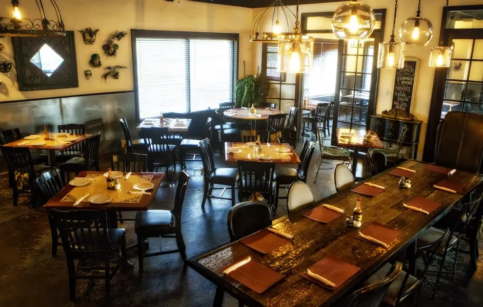 Restaurant dining room with individual and communal tables, eclectic decor.