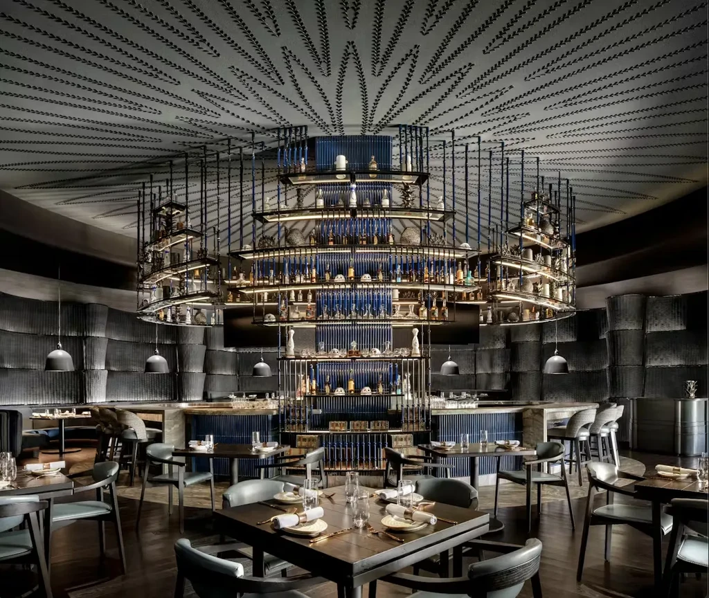 Luxurious restaurant interior featuring a multi-tiered circular bar and patterned ceiling.