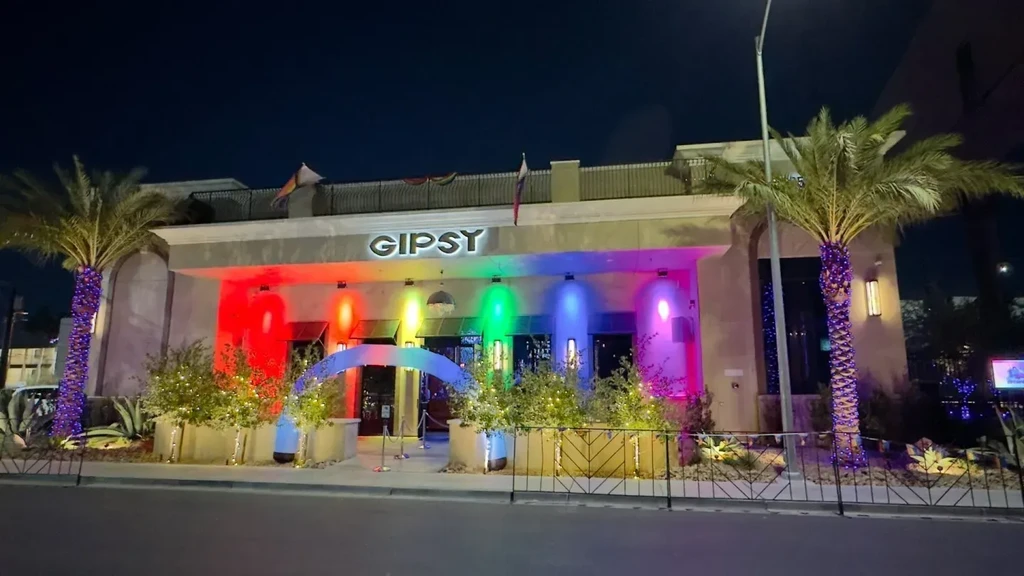 GIPSY building exterior at night with rainbow lights and illuminated palms.