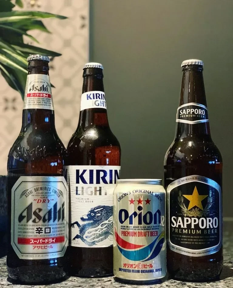 Still life of four Japanese beers: Asahi, Kirin, Orion, Sapporo.