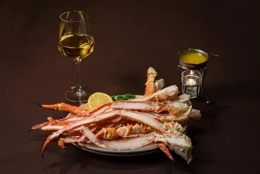 Snow crab legs, white wine, and a melted butter warmer.