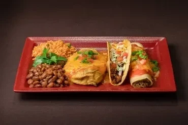 Platter of a Mexican combo meal: taco, enchilada, beans, and rice.