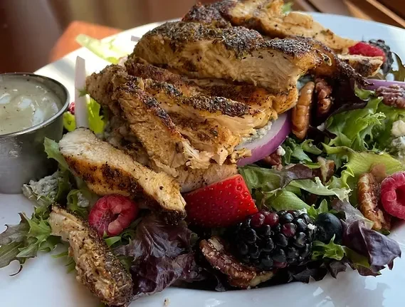 Grilled chicken salad with blue cheese, berries, pecans, and creamy dressing.