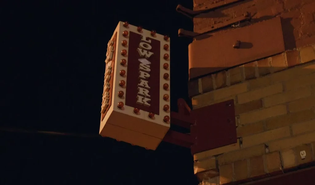 Vertical "LOW SPARK" sign with marquee lights on a brick building.