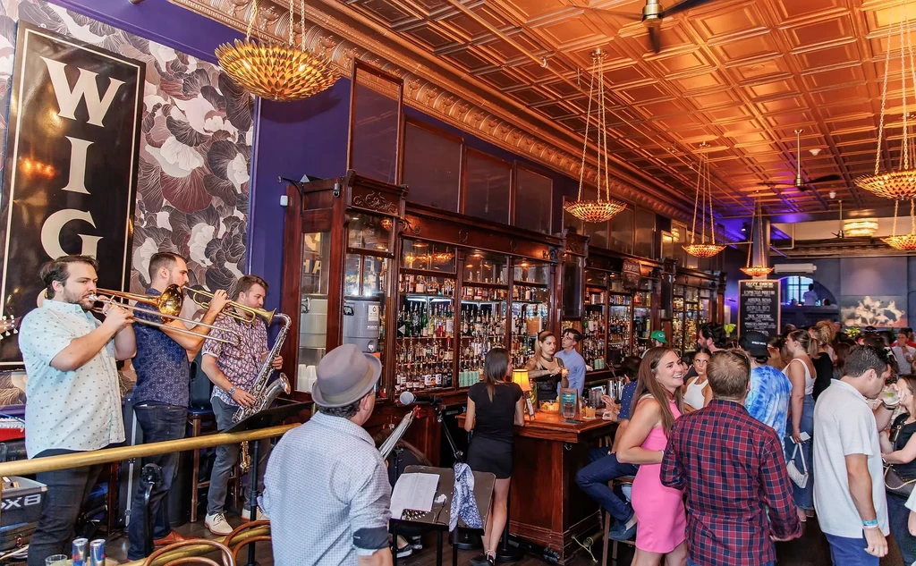 Live brass band entertains patrons in a vibrant, upscale bar.