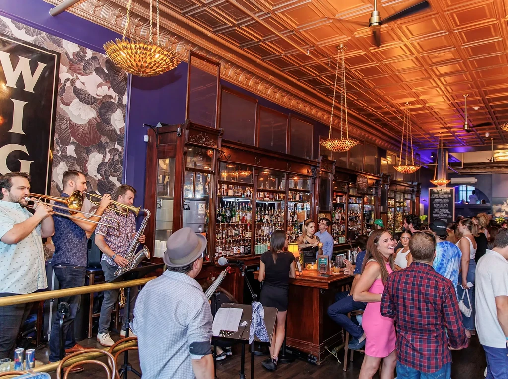 Vibrant bar interior featuring a live brass band and busy patrons.