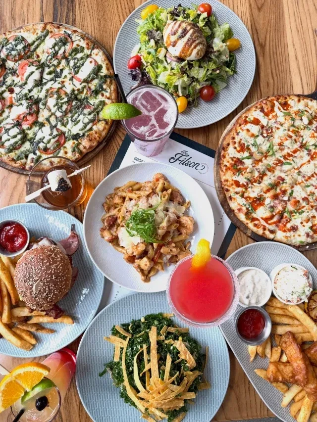 Flat lay photo of diverse food, cocktails, and "The Filson" menu.