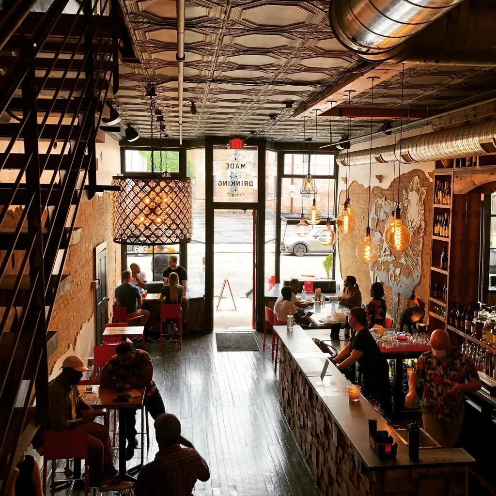 Industrial-chic bar interior with pressed tin ceiling and patrons.