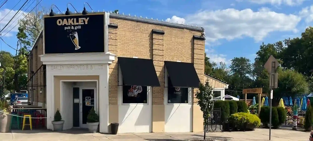 Oakley Pub & Grill exterior with outdoor patio shaded by umbrellas.