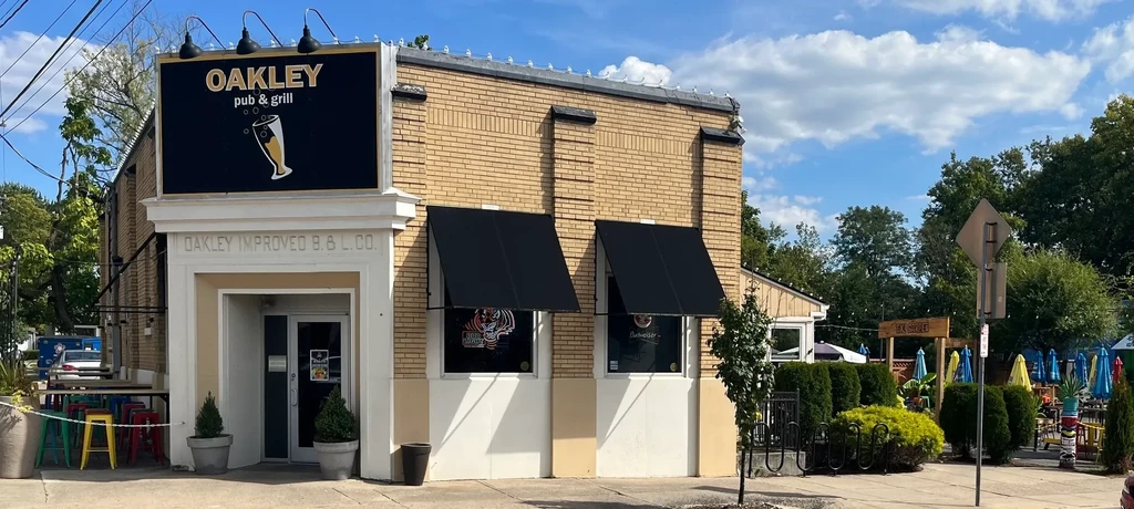 Oakley pub and grill exterior with outdoor patio and colorful seating.
