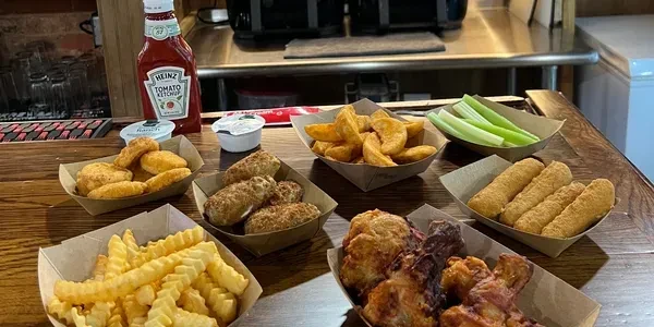 Various fried pub appetizers, including wings, fries, and mozzarella sticks.